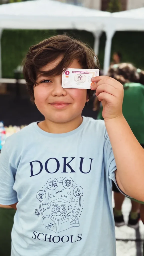 Doku Koleji tişörtüyle poz veren ilkokul öğrencisi